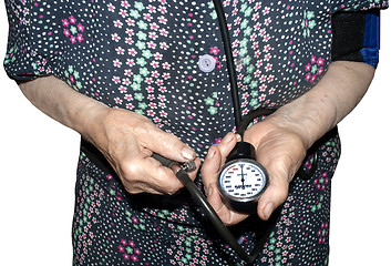 Image showing an elderly woman measures her pressure with a tonometer