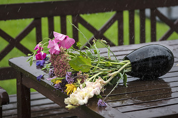 Image showing Rain over a vase with a bouquet of colorful flowers