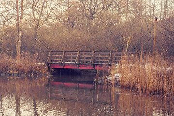 Image showing Small bridge with red paint by a river