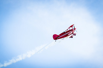 Image showing Red airplane with propellers and white smoke