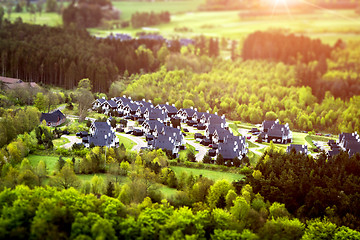 Image showing White houses with black roofs in a small forest