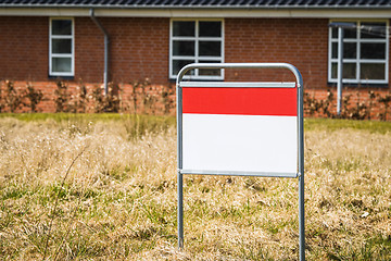 Image showing Real estate sign on a lawn in front of a house