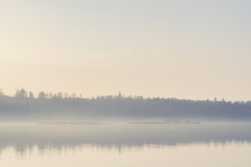 Image showing Mist hanging over a quiet lake in the early morning