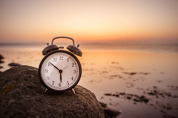 Image showing Alarm clock early in the morning on a rock