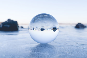 Image showing Glass orb balancing on ice on a frozen lake