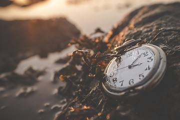 Image showing Old clock on a rock by the ocean