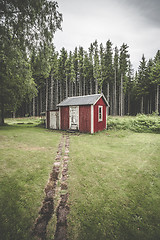 Image showing Trail leading up to a small red cabin