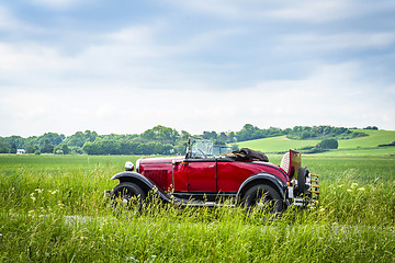 Image showing Red veteran car on a countryside road