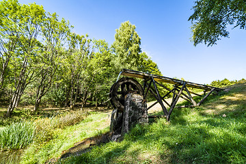 Image showing Old water mill on a meadow with green grass