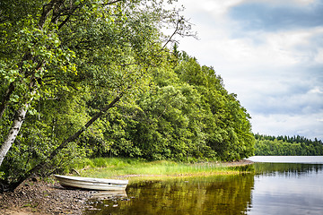 Image showing Boat at a river shore surrounded by a forest