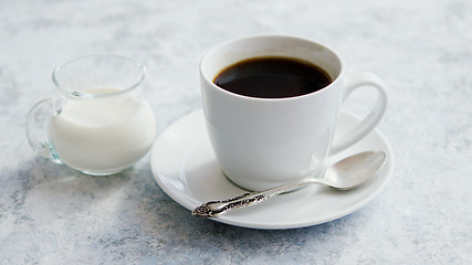 Image showing Cup of coffee and pitcher of milk