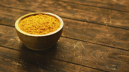 Image showing Small bowl of orange turmeric spice