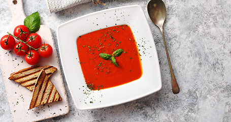 Image showing Red tomato soup with crisp bread and spoon