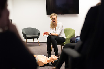 Image showing Instructor teaching first aid cardiopulmonary resuscitation course and use of automated external defibrillator on CPR workshop.