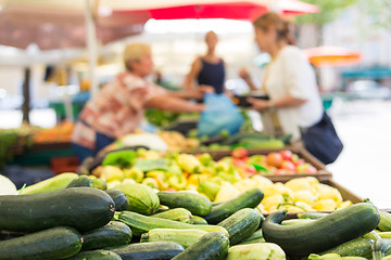 Image showing Blured unrecodnised people buying homegrown vegetable at farmers\' market stall with variety of organic vegetable.