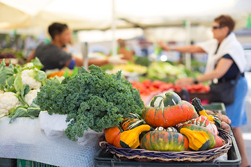 Image showing Blured unrecodnised people buying homegrown vegetable at farmers\' market stall with variety of organic vegetable.