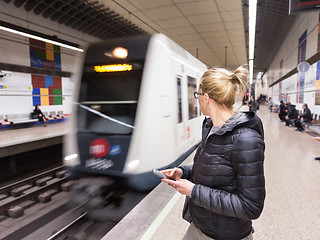 Image showing Woman with a cell phone waiting for metro.