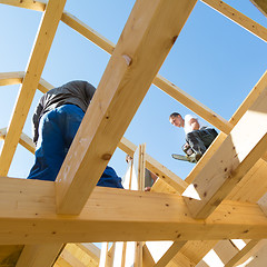 Image showing Builders at work with wooden roof construction.