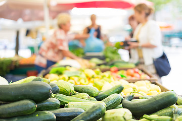 Image showing Blured unrecodnised people buying homegrown vegetable at farmers\' market stall with variety of organic vegetable.