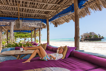 Image showing Relaxed woman in luxury tropical bar lounger, enjoying summer vacations on beautiful beach.