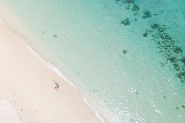 Image showing Aerial shot of woman enjoying the picture perfect white tropica beach on Mauritius island.