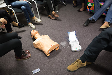 Image showing Instructor teaching first aid cardiopulmonary resuscitation course and use of automated external defibrillator on CPR workshop.