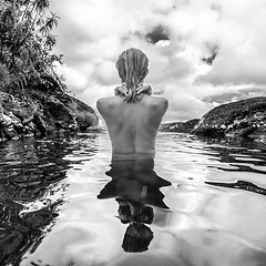 Image showing Naked woman bathing and relaxing in natural swimming pool in black and white.