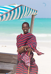 Image showing Traditonaly dressed maasai black man on picture perfect tropical Paje beach, Zanzibar, Tanzania, East Africa.