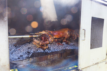 Image showing Traditional balkan dish - whole piglet grilled on the open fire.