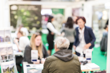 Image showing Anonymous blurred people discussing business at a trade fair.