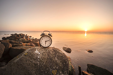 Image showing Alarm clock in the sunrise by the sea