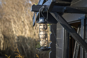 Image showing Bird feeder cage on a wooden shed