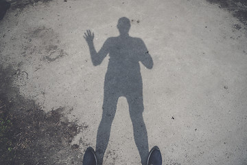 Image showing Male shadow on the ground waving