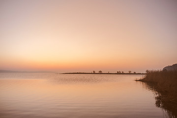 Image showing Sunrise by a lake with silhouettes