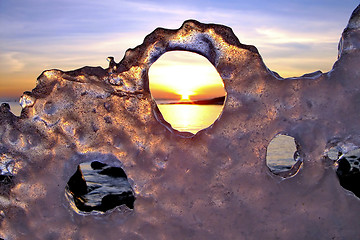 Image showing View of winter sunset through holes in ice