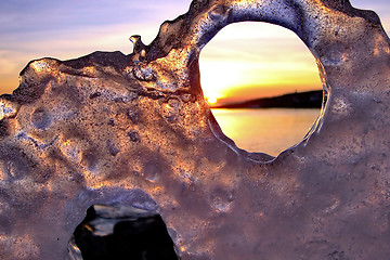 Image showing View of winter sunset through holes in ice