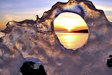 Image showing View of winter sunset through holes in ice