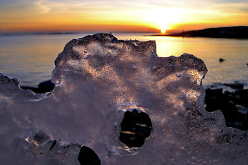 Image showing View of winter sunset through holes in ice