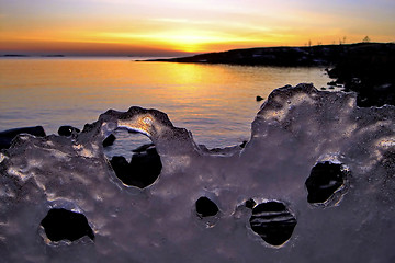 Image showing View of winter sunset through holes in ice