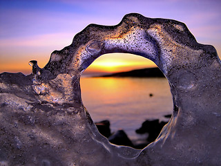 Image showing View of winter sunset through holes in ice