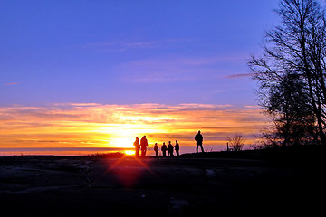 Image showing Dark silhouettes of people on winter sunset background
