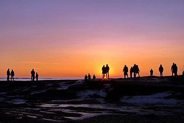 Image showing Dark silhouettes of people on winter sunset background