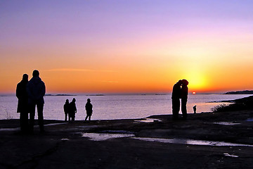 Image showing Dark silhouettes of people on winter sunset background