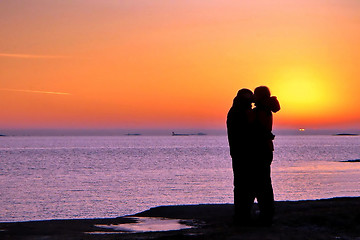 Image showing Dark silhouettes of people on winter sunset background