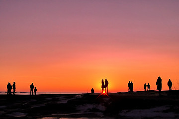 Image showing Dark silhouettes of people on winter sunset background