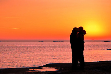 Image showing Dark silhouettes of people on winter sunset background