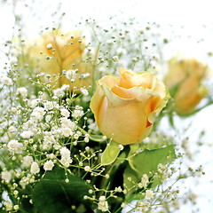 Image showing Beautiful bouquet of yellow roses and white little flowers with blur background