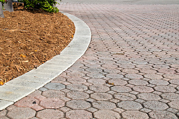 Image showing curved low angle brick paver driveway with mulch