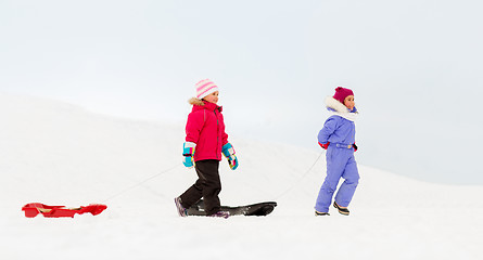 Image showing happy little girls with sleds walking in winter