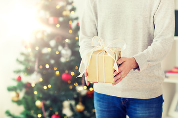 Image showing close up of man with christmas gift at home